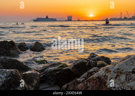 Sonnenuntergang am Strand in der Nähe der Stadt Vlorë in Albanien, die sich an der Bucht von Vlorë ausbreitet und von den Ausläufern der Ceraunischen Berge Ao umgeben ist Stockfoto