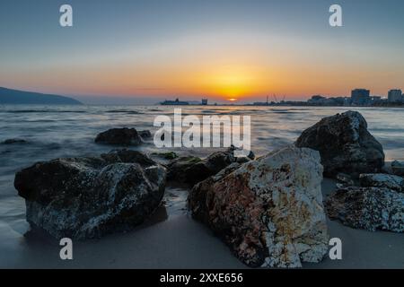 Sonnenuntergang am Strand in der Nähe der Stadt Vlorë in Albanien, die sich an der Bucht von Vlorë ausbreitet und von den Ausläufern der Ceraunischen Berge Ao umgeben ist Stockfoto