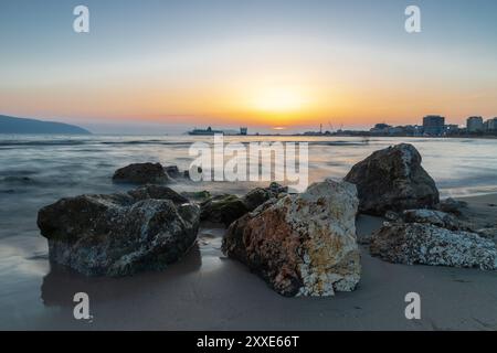 Sonnenuntergang am Strand in der Nähe der Stadt Vlorë in Albanien, die sich an der Bucht von Vlorë ausbreitet und von den Ausläufern der Ceraunischen Berge Ao umgeben ist Stockfoto