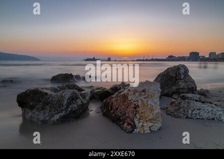 Sonnenuntergang am Strand in der Nähe der Stadt Vlorë in Albanien, die sich an der Bucht von Vlorë ausbreitet und von den Ausläufern der Ceraunischen Berge Ao umgeben ist Stockfoto