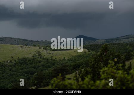 Dunkle Sturmwolken hängen bedrohlich über den kroatischen Bergen. Stockfoto