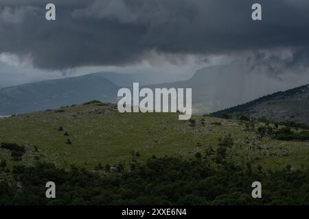 Dunkle Sturmwolken hängen bedrohlich über den kroatischen Bergen. Stockfoto