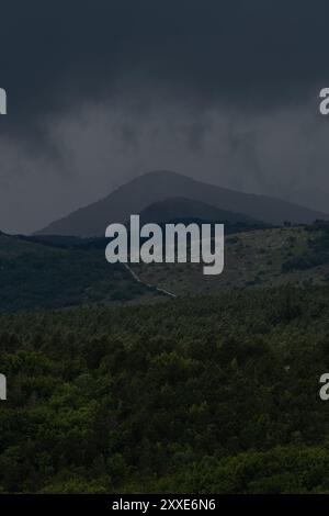 Dunkle Sturmwolken hängen bedrohlich über den kroatischen Bergen. Stockfoto