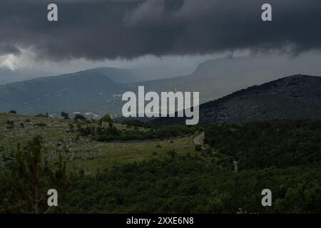 Dunkle Sturmwolken hängen bedrohlich über den kroatischen Bergen. Stockfoto