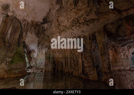 Große Höhle mit Wasser überflutet in der Grotte von Neptun in Sardinien, Italien, mit großen Säulen und Stalaktiten reflektiert im Wasser, ohne Menschen Stockfoto