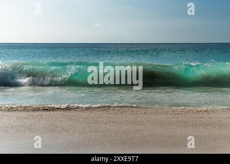 Türkisfarbene Wellen brechen am Sandstrand auf den Seychellen. Stockfoto