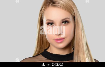 Schöne lächelnde blonde Frau mit langen Haaren, sauberer Haut und frischem Make-up. Sie hat schöne blaue Augen mit Pupillenheterochromie. Ästhetisches Cosmetol Stockfoto