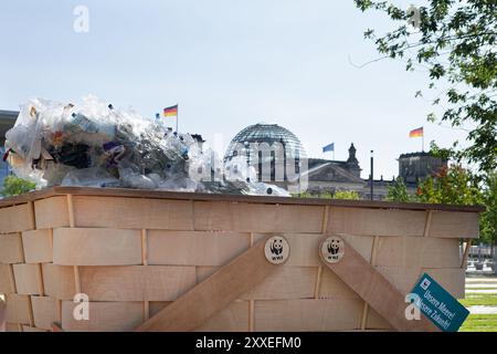 Berlin, Deutschland, 24. September 2024. Umweltaktivisten nehmen an einem bundesweiten Protestpicknick des WWF Deutschland gegen die Plastikkrise vor dem Bundeskanzleramt in Berlin teil. Die Demonstranten versammeln sich mit bunten Bannern und einem riesigen symbolischen Picknickkorb, der mit Plastikabfällen gefüllt ist, und fordern einen starken globalen vertrag der Vereinten Nationen, um die Plastikverschmutzung während der laufenden UN-Verhandlungen zu beenden. Felix Wolf/Alamy Live News Stockfoto