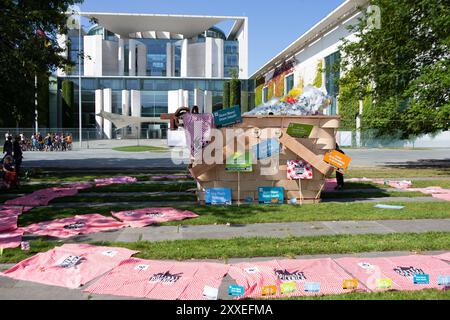 Berlin, Deutschland, 24. September 2024. Umweltaktivisten nehmen an einem bundesweiten Protestpicknick des WWF Deutschland gegen die Plastikkrise vor dem Bundeskanzleramt in Berlin teil. Die Demonstranten versammeln sich mit bunten Bannern und einem riesigen symbolischen Picknickkorb, der mit Plastikabfällen gefüllt ist, und fordern einen starken globalen vertrag der Vereinten Nationen, um die Plastikverschmutzung während der laufenden UN-Verhandlungen zu beenden. Felix Wolf/Alamy Live News Stockfoto