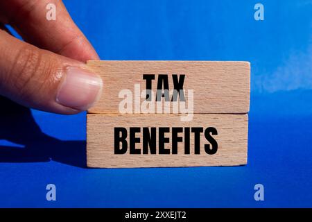 Meldung über Steuervorteile auf Holzblöcken mit blauem Hintergrund. Symbol für konzeptionelle Steuervorteile. Kopierbereich. Stockfoto