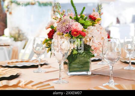 Blick auf einen Tisch bei einer Veranstaltung mit einem wunderschönen Blumenstrauß. Stockfoto