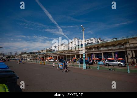 Madeira Drive Walkway Promenade in Brighton England zeigt Bogenway Geschäfte und beeindruckendes weißes Gebäude auf der Marine Parade mit Blick auf das Meer. Stockfoto