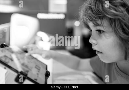 Kind im Computerladen. Digitale Geräte und Elektronik. Verkauf von Laptops. Stockfoto