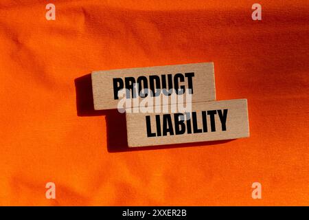 Hinweis zur Produkthaftung auf Holzblöcken mit orangefarbenem Hintergrund. Symbol für konzeptionelle Produkthaftung. Kopierbereich. Stockfoto