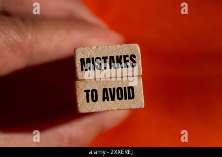 Fehler, um Nachrichten auf Holzblöcken mit orangefarbenem Hintergrund zu vermeiden. Konzeptionelle Fehler, um Symbol zu vermeiden. Kopierbereich. Stockfoto