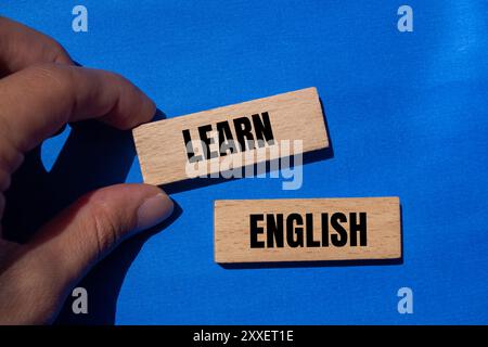 Lernen Sie englische Botschaft auf Holzblöcken mit blauem Hintergrund. Symbol für konzeptuelles Lernen englisch. Kopierbereich. Stockfoto
