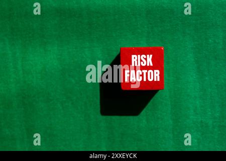 Risikofaktor-Meldung auf rotem Holzwürfel mit grünem Hintergrund. Konzeptionelles Risikofaktorsymbol. Kopierbereich. Stockfoto
