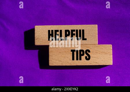 Hilfreiche Tipps auf Holzblöcken mit violettem Hintergrund. Symbol für hilfreiche Tipps. Kopierbereich. Stockfoto