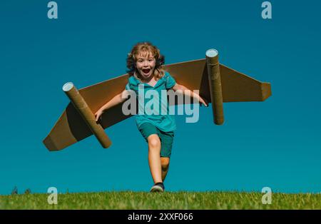 Aufgeregt Kind mit Jet Pack Superhelden. Kinderpilot läuft vor dem Hintergrund des Sommerhimmels. Erfolg, Leader und Sieger Konzept. Fantasie, Freiheit für Kinder. Stockfoto