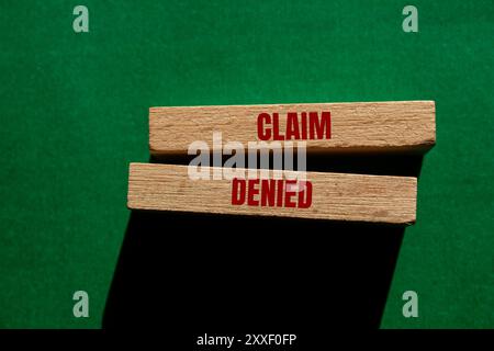 Meldung „Reklamation abgelehnt“ auf Holzblöcken auf grünem Hintergrund. Symbol für konzeptionelle Ansprüche abgelehnt. Kopierbereich. Stockfoto