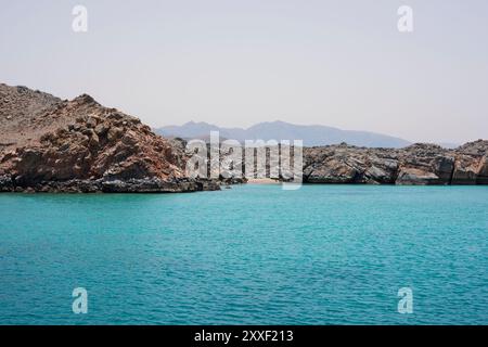 Felsige Klippen und kleiner Strand in einer fjordartigen Umgebung der Halbinsel Musandam, Sultanat Oman Stockfoto