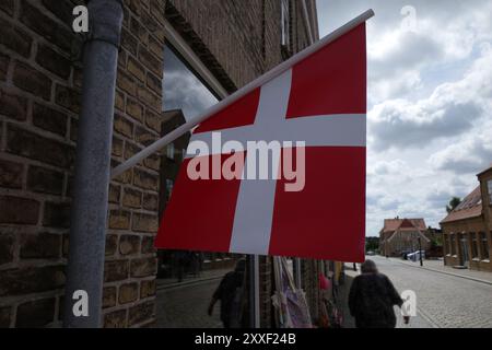Eine kleine dänische Flagge hängt an der Fassade eines Ladens Stockfoto