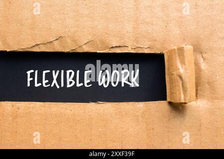 Flexible Arbeitsbotschaft auf zerrissenem Papppapier mit schwarzem Hintergrund. Konzeptionelles flexibles Arbeitssymbol. Kopierbereich. Stockfoto