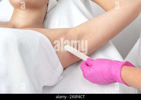 ELOs-Haarentfernungsverfahren am Körper einer Frau. Kosmetikerin macht Laser Haarentfernung in einem Schönheitssalon. Hardware-ipl-Kosmetologie Stockfoto