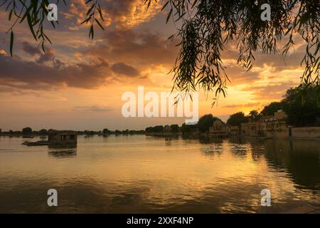 Schöner Sonnenuntergang am Gadisar Lake, Jaisalmer, Rajasthan, Indien. Untergehende Sonne und bunte Wolken am Himmel mit Blick auf den Gadisar See. Verbunden mit Ind Stockfoto