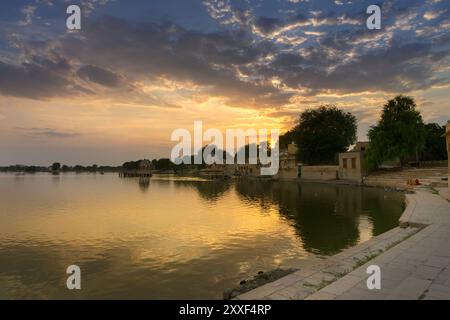 Schöner Sonnenuntergang am Gadisar Lake, Jaisalmer, Rajasthan, Indien. Untergehende Sonne und bunte Wolken am Himmel mit Blick auf den Gadisar See. Verbunden mit Ind Stockfoto