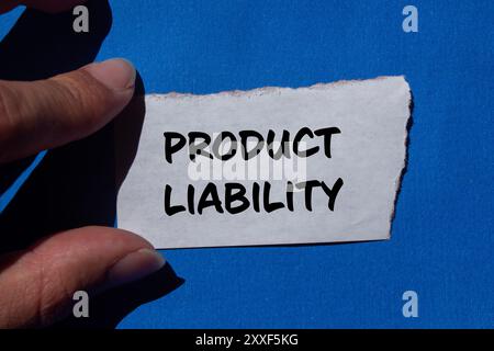 Meldung zur Produkthaftung auf gerissenem Papier mit blauem Hintergrund. Symbol für konzeptionelle Produkthaftung. Kopierbereich. Stockfoto