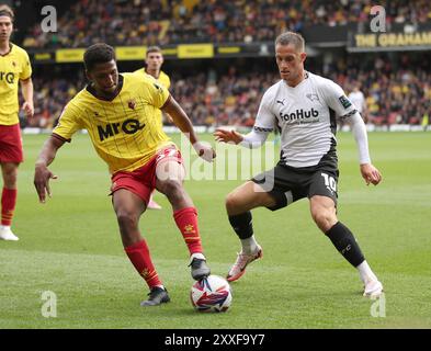 Watfords Kwadwo Baah (links) wird vom Derby County Jerry Yates (rechts) während des Sky Bet Championship Matches in der Vicarage Road, Watford, herausgefordert. Bilddatum: Samstag, 24. August 2024. Stockfoto