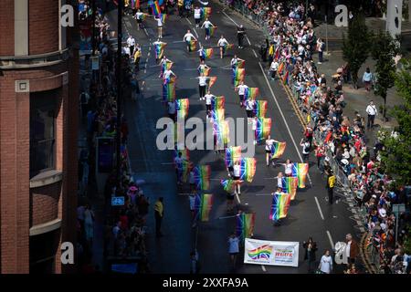 Manchester, Großbritannien. August 2024. Die LGBTQ-Community kommt während der Pride Parade mit Bannern und Flaggen zusammen. Die dreitägige Veranstaltung bietet Live-Musik und Partys in der ganzen Stadt, wobei die Hauptparade am Samstag stattfindet. Andy Barton/Alamy Live News Stockfoto