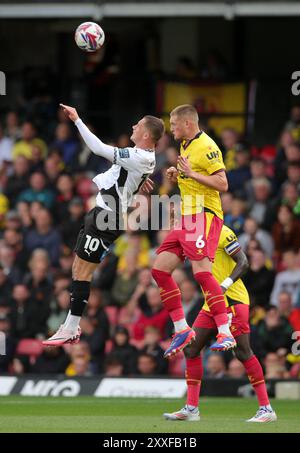 Jerry Yates (links) von Derby County fordert Mattie Pollock (rechts) von Watford für einen Kopfball während des Sky Bet Championship-Spiels in der Vicarage Road, Watford, an. Bilddatum: Samstag, 24. August 2024. Stockfoto