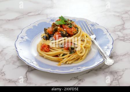 Spaghetti alla puttanesca, ein traditionelles italienisches Napoli-Pastagericht mit schwarzen Oliven, Kapern, Sardellen und Tomaten. Stockfoto