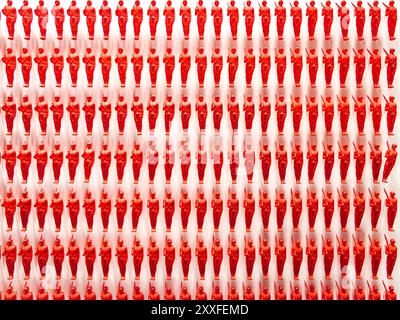 Grafische abstrakte, mehrere rote Plastiksoldaten an der Wand montiert. Rotes Armeekonzept Stockfoto