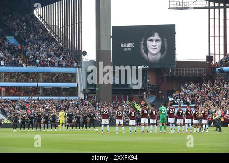 Spieler und Fans von Aston Villa und Arsenal beobachten einen minutenlangen Applaus zum Gedenken an den ehemaligen Spieler Alan Little während des Premier League-Spiels im Villa Park, Birmingham. Bilddatum: Samstag, 24. August 2024. Stockfoto