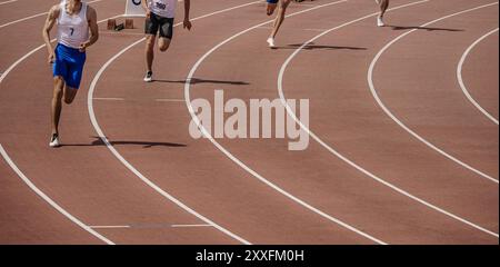 Starte eine Gruppe von Athleten, die im Stadion sprinten, Leichtathletik-Wettkampf Stockfoto