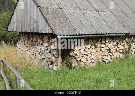Gestapeltes Brennholz im Außenlager an sonnigen Tagen Stockfoto