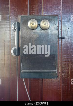 Antike altes Telefon auf der hölzernen Wand hängen, ein altes Telefon vintage auf alten Wand Stockfoto