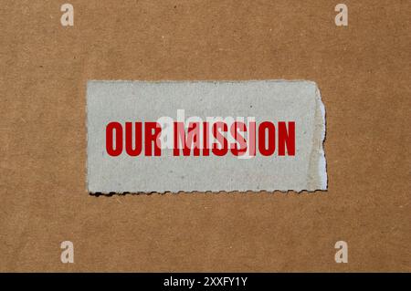 Unsere Botschaft steht auf zerrissenem Papier mit Papphintergrund. Konzeptionelles unser Missionssymbol. Kopierbereich. Stockfoto