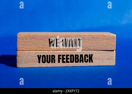 Wir möchten, dass Ihre Feedback-Nachricht auf Holzblöcken mit blauem Hintergrund geschrieben wird. Konzeptionell möchten wir Ihr Feedback-Symbol. Kopierbereich. Stockfoto