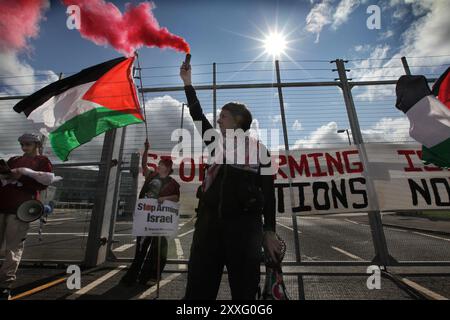 Blackburn, England, Großbritannien. August 2024. Ein Demonstrant hält während der Demonstration vor den Haupttoren des BAE Systems eine rote Rauchfackel. Demonstranten beschuldigen BAE Systems, am Völkermord in Gaza beteiligt zu sein, indem sie Teile für die F-35-Kampfflugzeuge in ihrer Anlage in Samlesbury herstellen, die beim Luftangriff auf Gaza und den Jemen eingesetzt wurden. Seit dem 10/24 wurden über 5000 Luftangriffe auf Gaza gerichtet, bei denen Tausende von Zivilisten getötet wurden, darunter 16.500 Kinder. Quelle: ZUMA Press, Inc./Alamy Live News Stockfoto