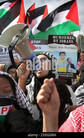 Blackburn, England, Großbritannien. August 2024. Während der Demonstration vor den Haupttoren der BAE Systems-Anlage ruft und singt ein Demonstrant durch ein Megaphon. Demonstranten beschuldigen BAE Systems, am Völkermord in Gaza beteiligt zu sein, indem sie Teile für die F-35-Kampfflugzeuge in ihrer Anlage in Samlesbury herstellen, die beim Luftangriff auf Gaza und den Jemen eingesetzt wurden. Seit dem 10/24 wurden über 5000 Luftangriffe auf Gaza gerichtet, bei denen Tausende von Zivilisten getötet wurden, darunter 16.500 Kinder. Quelle: ZUMA Press, Inc./Alamy Live News Stockfoto