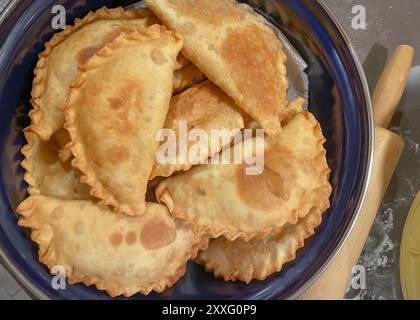 Chebureki: In der Pfanne gebratene Kuchen mit Fleisch und Zwiebeln in einer Pfanne Stockfoto