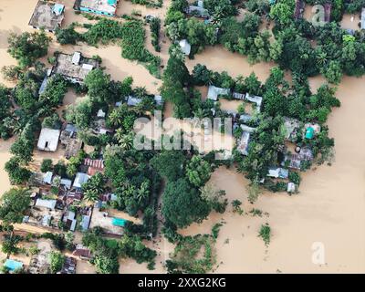 Dhaka, Bangladesch. August 2024. Menschen laufen in Hochwasser an der Straße nach einer weit verbreiteten Sturzflut im Bezirk Cumilla, Bangladesch, 24. August 2024. Laut Angaben des Ministeriums für Katastrophenmanagement und -Hilfe während einer Pressekonferenz im Sekretariat wurden die Überschwemmungen durch schwere Monsunregenfälle ausgelöst und haben seit Beginn der Woche mindestens 42 Menschen in Bangladesch und Indien getötet, viele davon durch Erdrutsche. Foto: Habibur Rahman/ABACAPRESS. COM Credit: Abaca Press/Alamy Live News Stockfoto