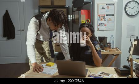 Mann und Frau, als Detektiv und Polizist gekleidet, analysieren Beweise in einem überfüllten Büro. Stockfoto