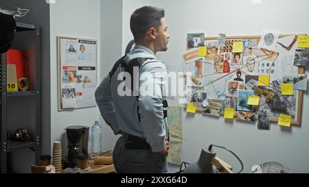 Ein junger Mann analysiert Beweise auf einer Polizeiwache und ruft ein Detektivthema auf. Stockfoto