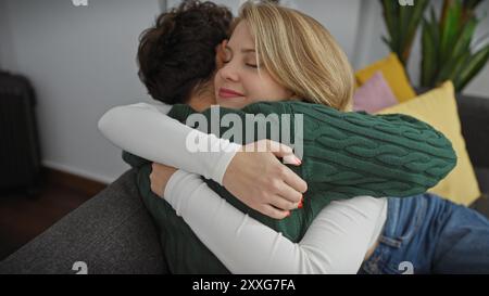 Ein liebevolles Paar umarmt sich herzlich in ihrem gemütlichen Wohnzimmer und symbolisiert die Zweisamkeit und Zuneigung drinnen. Stockfoto