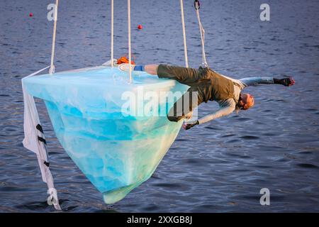 London, UK, 24. August 2024. Dritter Auftritt, Darsteller: Anna. THAW ist die europäische Premiere einer Aufführung der australischen Theatergruppe Legs on the Wall als Reaktion auf die verheerenden Buschbrände von 2019/20 und den globalen Klimawandel. Die Performance, die auf dem Docklands Campus der University of East London stattfindet, bringt die Zuschauer mit einer Performance von über 8 Stunden mit dem dringenden Bedarf an globalen Klimaschutzmaßnahmen konfrontiert und sieht einen Darsteller auf einem riesigen, 2,5 Tonnen schweren Eisblock, der an einem hohen Kran hängt. Quelle: Imageplotter/Alamy Live News Stockfoto